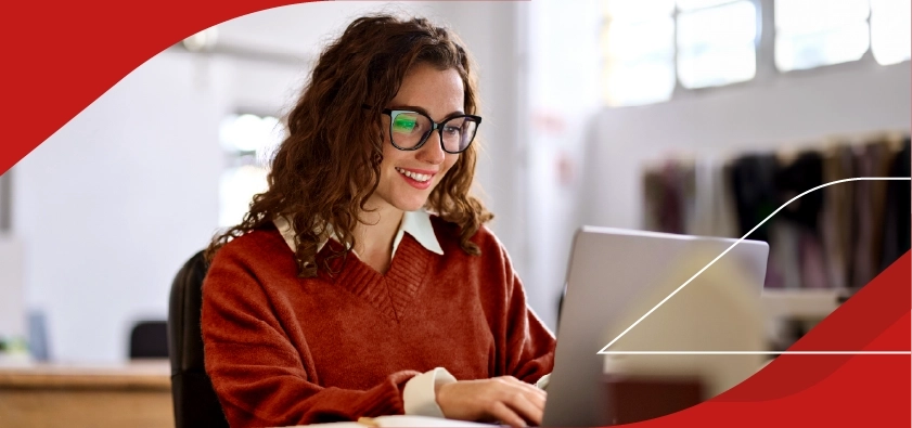 Mujer trabajadora independiente sonriendo frente a su laptop